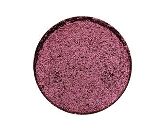 May include: A single round eyeshadow pan with a deep burgundy color and a shimmer finish.