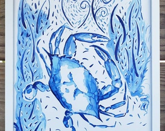 Puede incluir: Lámina artística de cangrejo azul enmarcada en blanco. La pintura a la acuarela presenta un cangrejo azul detallado con algas estilizadas y espirales en forma de corazón sobre un fondo blanco. La obra está enmarcada en un marco de madera blanco.