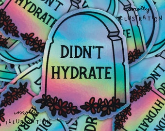 May include: A holographic sticker with a rainbow gradient background. The sticker features a tombstone with the text "Didn't Hydrate" and a floral border.