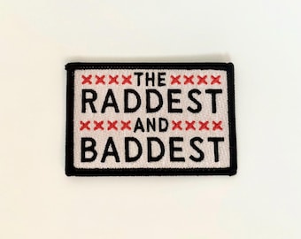 May include: Rectangular patch with the words "THE RADDEST AND BADDEST" in black block letters. The text is on a cream-coloured background with red cross-stitch accents and a black border.