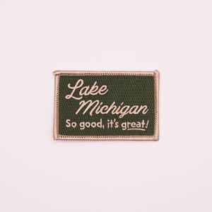 May include: A green embroidered patch with white text that reads "Lake Michigan So good, it's great!"