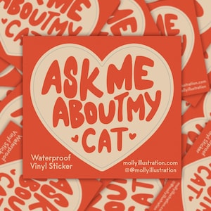 May include: A red heart-shaped sticker with white text that reads "Ask Me About My Cat". The sticker is waterproof and made of vinyl.