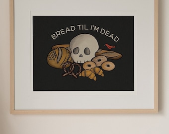 May include: A black and white illustration of a skull surrounded by various types of bread, including a pretzel, a loaf of bread, and a croissant. The text "BREAD TIL I'M DEAD" is written in white letters above the skull. A small red bird is perched on a piece of bread.