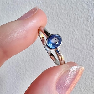 Pu&ograve; includere: Un anello d'argento con una pietra ovale blu.