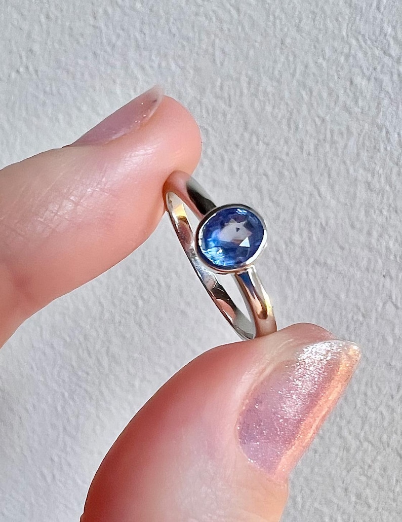 Pu&ograve; includere: Un anello d'argento con una pietra ovale blu.
