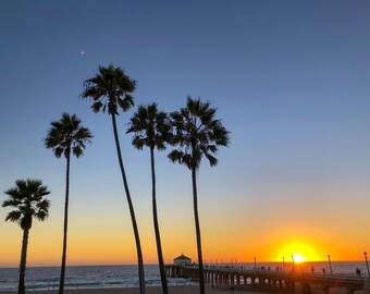 Słońce zachodzi nad molo Manhattan Beach