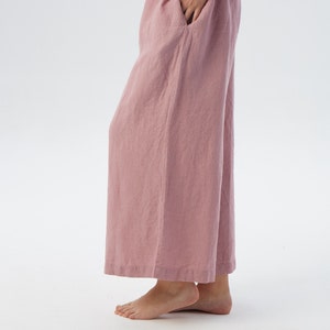 Puede incluir: Pantal&oacute;n de pierna ancha en color rosa polvoriento. El pantal&oacute;n est&aacute; hecho de una tela de lino suave y tiene un corte holgado.