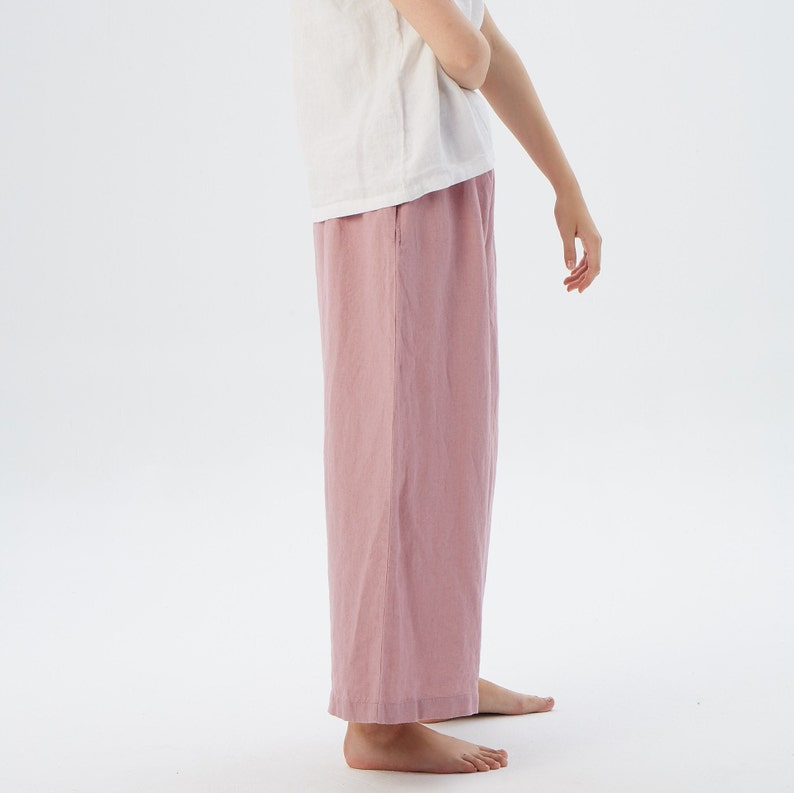 Puede incluir: Un pantal&oacute;n de pierna ancha en color rosa polvoriento. El pantal&oacute;n est&aacute; hecho de una tela de lino suave y tiene un corte holgado.