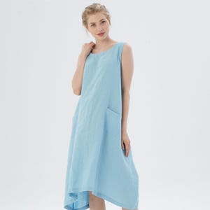 May include: A light blue sleeveless linen dress with a single pocket on the left side.