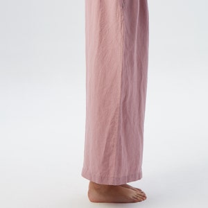 Puede incluir: Un pantal&oacute;n de pierna ancha en color rosa polvoriento. El pantal&oacute;n est&aacute; hecho de una tela de lino suave y tiene un corte holgado.