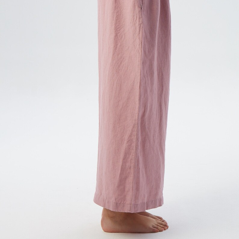 Puede incluir: Un pantal&oacute;n de pierna ancha en color rosa polvoriento. El pantal&oacute;n est&aacute; hecho de una tela de lino suave y tiene un corte holgado.