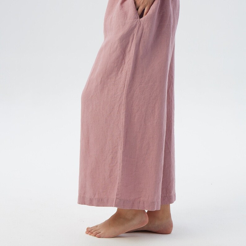 Puede incluir: Pantal&oacute;n de pierna ancha en color rosa polvoriento. El pantal&oacute;n est&aacute; hecho de una tela de lino suave y tiene un corte holgado.