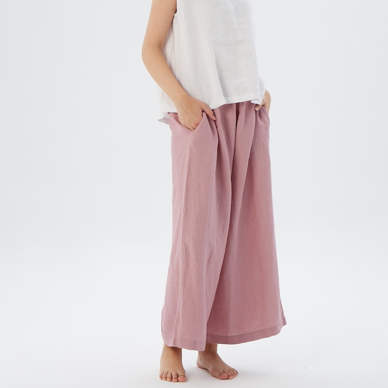 Puede incluir: Un pantal&oacute;n de pierna ancha en color rosa polvoriento. El pantal&oacute;n est&aacute; hecho de una tela de lino suave y tiene un corte holgado.