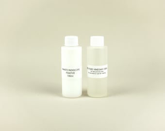 May include: Two white plastic bottles with labels. The bottle on the left is labeled "Yamato Indigo Dye Fixative 100ml". The bottle on the right is labeled "100% Pure Vinegar (100ml) For dye process only. Do not drink or use for cooking."
