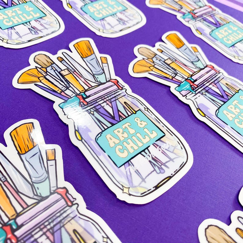 Puede incluir: Una pegatina con un tarro de cristal lleno de pinceles y el texto "Art & Chill" en una fuente turquesa y amarilla.