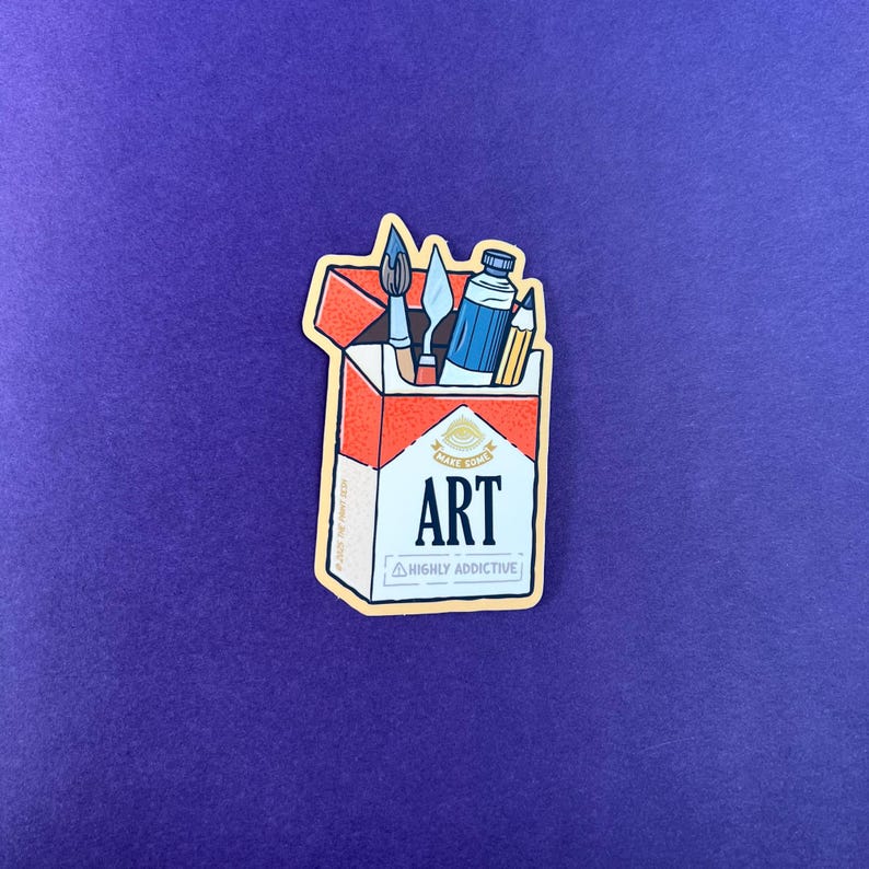 K&ouml;nnte beinhalten: Ein Aufkleber mit einem Zigarettenpackungsdesign, das mit Kunstutensilien gef&uuml;llt ist. Die Packung ist rot und wei&szlig;, mit dem Wort "ART" in fetten Buchstaben. Der Text "HIGHLY ADDICTIVE" steht darunter. Enthalten sind ein Pinsel, ein Spachtel, eine Farbtube und ein Bleistift.