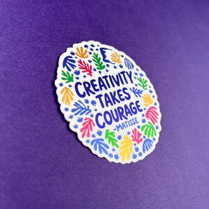 May include: A circular sticker with a scalloped edge featuring the blue text "CREATIVITY TAKES COURAGE -MATISSE" in the center. The design is surrounded by a colorful pattern of abstract leaf and organic shapes in yellow, pink, green, and blue.