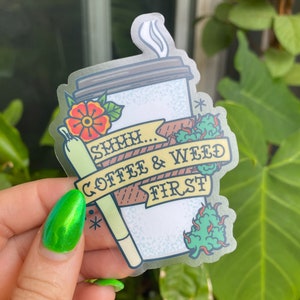 May include: A clear sticker with a cartoon illustration of a coffee cup, a joint, and a green leafy plant. The text reads "SMMH... COFFEE & WEED FIRST".