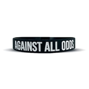 May include: Black silicone wristband with the white text "AGAINST ALL ODDS".