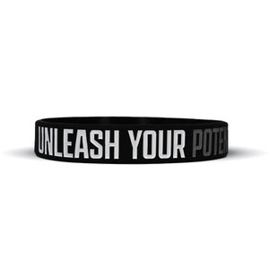 May include: Black silicone bracelet with the text "UNLEASH YOUR POTENTIAL" in white and gray lettering.
