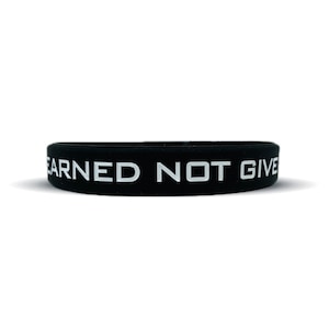 May include: Black silicone wristband with the white text "EARNED NOT GIVEN".