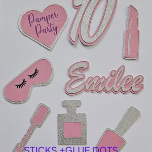May include: Pink and silver glitter paper cutouts for a pamper party. The cutouts include the number 10, a heart with the text "Pamper Party", a lipstick, a sleep mask, the name "Emilee", a perfume bottle, a nail polish bottle, and a mascara wand. The text "STICKS + GLUE DOTS INCLUDED" is also included.