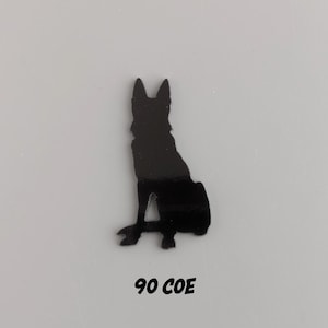 May include: Black silhouette of a German Shepherd dog sitting, cut out from a black material. The text "90 COE" is printed below the silhouette.