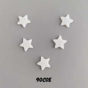 May include: Five white star-shaped embellishments on a gray background. The text "90COE" is printed below the stars.