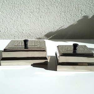 Pode incluir: Um conjunto de três canecas de cerâmica com acabamento fosco e salpicado. As canecas são em tons de creme, cinza claro e cinza escuro. Cada caneca tem um design simples e minimalista, perfeito para café ou chá.