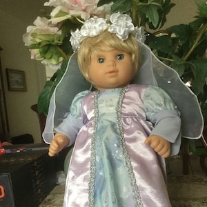 For 15 or 16” dolls like Bitty Twin,a satin Princess ball gown in lavender and blue with silver trim at each side of the center panel.