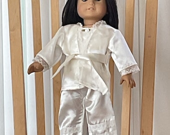 An ivory three piece pajama set ,in a silky fabric,white lace and ribbon flower trim, for 18” dolls like American Girl Ivy.