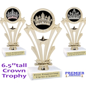May include: A 6.5 inch tall gold trophy with a black and white crown design. The trophy has five gold stars and a white marble base. The base has the text "Free Engraving Up to 2 Lines" on it.