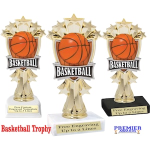 May include: Gold basketball trophy with a star design and a basketball on the front. The trophy has a black base and a white base with the text "Free Engraving Up to 2 Lines".