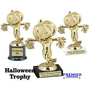 May include: Three gold-colored Halloween trophies shaped like scarecrows with pumpkin heads. Each trophy has a base with space for engraving. The text "Halloween Trophy" is at the bottom.