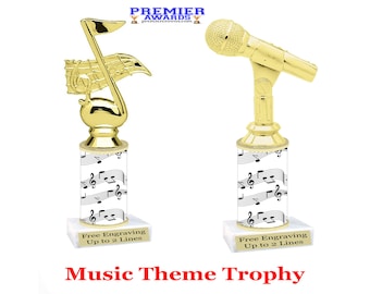 May include: Two gold-colored music-themed trophies. The trophy on the left features a musical note with a flag. The trophy on the right features a microphone. Both trophies have a white base with a musical note pattern. The text "Free Engraving Up to 2 Lines" is on the base of each trophy. The text "Music Theme Trophy" is below the trophies.