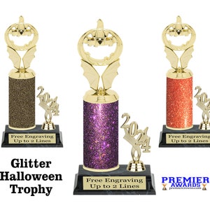 May include: Three gold glitter Halloween trophy awards with a pumpkin head design. The trophies have a black base with the text "Free Engraving Up to 2 Lines".