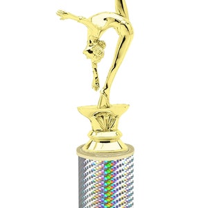 May include: Gold-colored trophy with a gymnast figurine on top. The base is a silver cylinder with a holographic pattern and a white marble base. The base has the text "Free Engraving Up to 2 Lines".