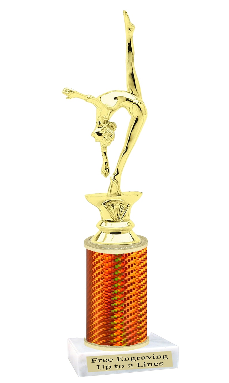 May include: Gold-colored trophy with a gymnast figure on top. The base is a cylinder with an orange and yellow pattern. The base is on a white marble base with the text "Free Engraving Up to 2 Lines".