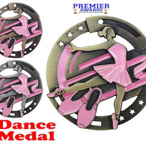 May include: A gold-tone metal dance medal with a pink ballerina figure and a pink ribbon. The medal has a circular design with five stars around the edge. The text "Dance Medal" is printed in red below the medal.