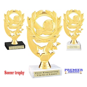 May include: Gold soccer trophy with a star design and a laurel wreath. The trophy has a white base with the text "Free Engraving Up to 2 Lines".