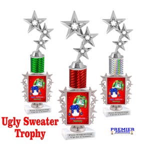 May include: Three silver trophy awards with a red, green, and iridescent base. Each trophy features a star design and a red frame with a picture of an ugly Christmas sweater. The text "Ugly Sweater Trophy" is printed below the trophies.