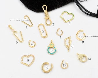 May include: Assortment of 14 gold-tone jewelry clasps with various designs, including hearts, circles, lightning bolts, and a lobster claw clasp. Each clasp is adorned with colorful gemstones.