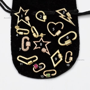 May include: A collection of 13 gold-toned earrings with different shapes and designs. The earrings feature various gemstones, including diamonds, rubies, and emeralds. The earrings are displayed on a black velvet background.