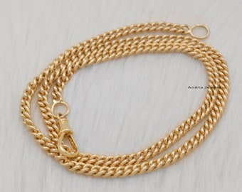 May include: A gold chain necklace with a lobster clasp fastening. The chain is a curb style with a slightly rounded design.