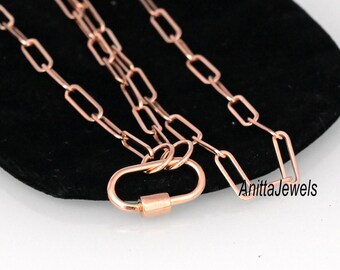 May include: A rose gold chain necklace with a lobster clasp closure. The chain is made of small, rectangular links.