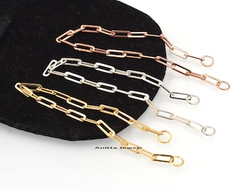 May include: Three gold, silver, and rose gold chain bracelets with a box clasp and jump ring closure. The bracelets are on a black velvet background.