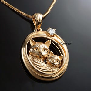 May include: Gold-tone necklace with a round pendant featuring two cats in a circle with a single clear rhinestone. The pendant has a detailed design and the text "AnittaJewels" is engraved on the side.