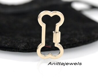 May include: Gold-toned bone-shaped keychain with a spring-loaded clasp. The keychain is a popular accessory for dog lovers.