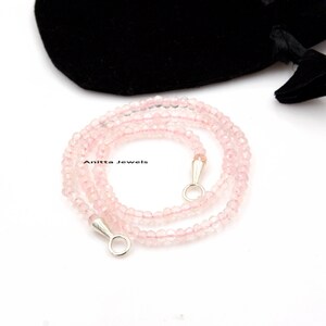 May include: A delicate pink rose quartz necklace with silver clasps. The necklace is made of small, round beads and is approximately 18 inches long.