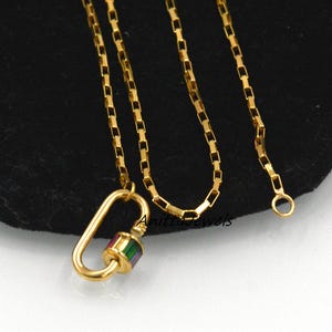 Peut inclure: Collier en chaîne dorée avec un pendentif mousqueton coloré. Le pendentif est orné d'une pierre multi-colore.